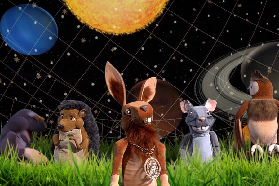 Zvieratká v tráve na pozadí oblohy a obrázkov planét slnečnej sústavy.